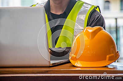 The yellow safety helmet and Business man in Construction industry is working in on computer Stock Photo