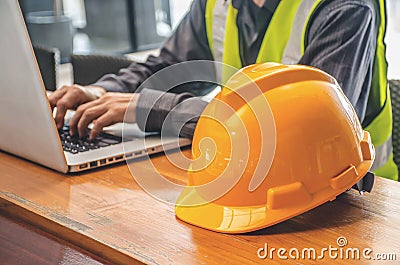 The yellow safety helmet and Business man in Construction industry is working in on computer. Stock Photo
