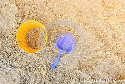 Yellow sand pail and blue shovel at the beach Stock Photo