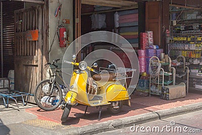 Yellow scooter parked on pavement in Chinatown, Bangkok, Thailand Editorial Stock Photo