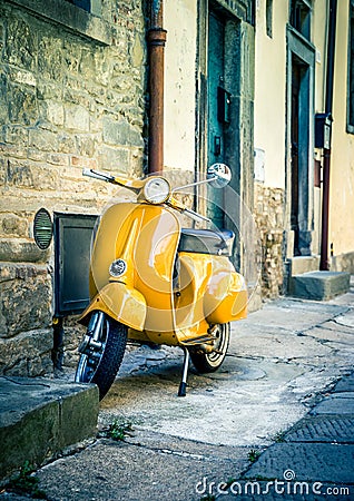 Yellow scooter in tuscan Cortona town Stock Photo