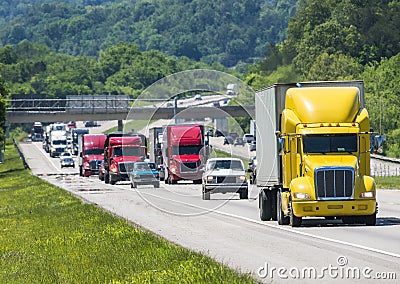 A yellow semi leads a packed line of traffic down an interstate in Tennessee Stock Photo