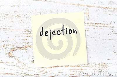 Yellow sheet of paper with word dejection. Reminder concept Stock Photo