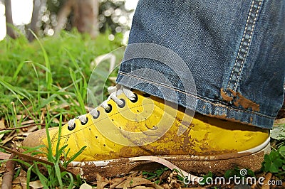 Yellow shoes full of mud Stock Photo