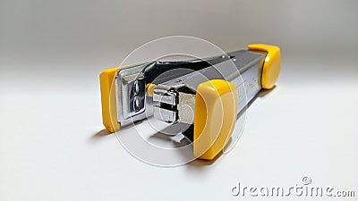 Yellow and Silver Iron Stepler on White Background Stock Photo