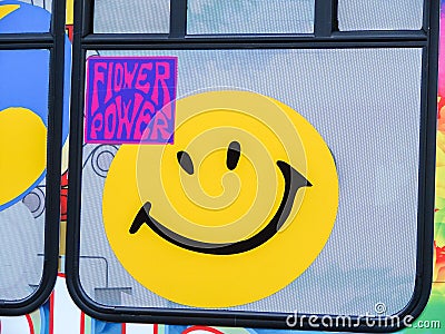 Yellow Smiley Face with Flower Power on a bus window Editorial Stock Photo