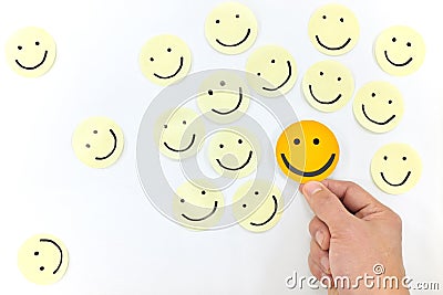 A yellow smiling face icon among a group of happy face emoticons. Positivity, attraction and happiness. Stock Photo
