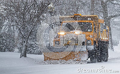 Yellow snow plow clearing roads suring peak of snow storm Editorial Stock Photo
