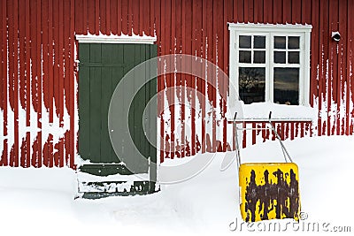 Yellow snow shovel outside by an old building Stock Photo