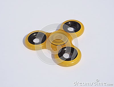 Yellow spinner toy on a white background Stock Photo