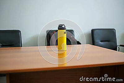 Yellow sport bottle with water on a wooden table. Selective focus Stock Photo