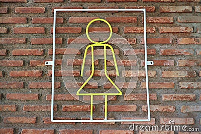 Yellow steel coil signs, female toilet symbols on brick walls, background Stock Photo