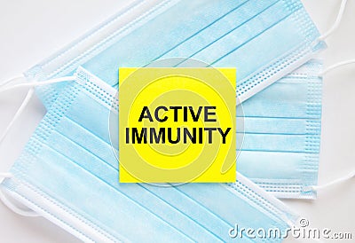 Yellow sticker with text Active Immunity lying on the masks Stock Photo