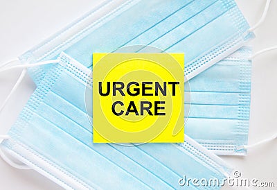 Yellow sticker with text Urgent Care lying on the masks Stock Photo