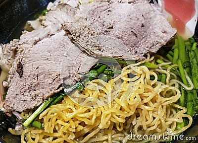 Yellow strands of egg noodles, mixed with lean sliced pork meat and vegetable ingredients Stock Photo