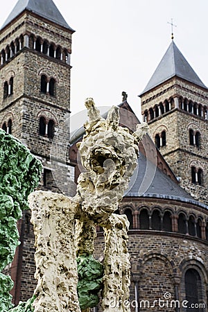 Yellow strange statue with old european church as background Editorial Stock Photo