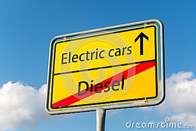 Yellow street sign with electric cars ahead leaving diesel behind Stock Photo