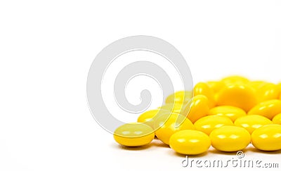 Yellow sugar coated tablets pills on white background Stock Photo