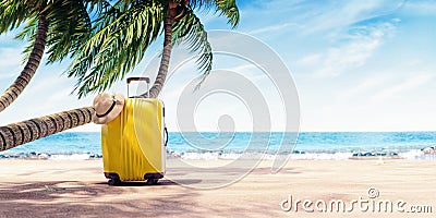 Yellow suitcase under palm tree on sunny beach, travel background Stock Photo