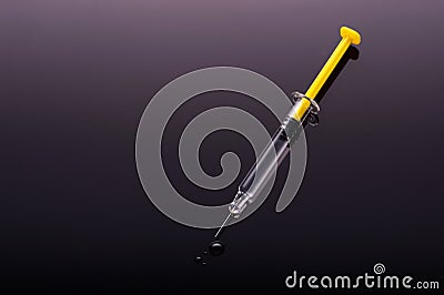 Yellow Syringe on black background Stock Photo