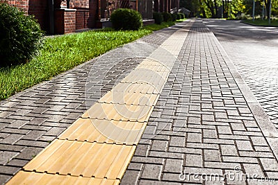 Yellow tactile paving on walkway, tactile ground surface indicators for blind and visually impaired Stock Photo