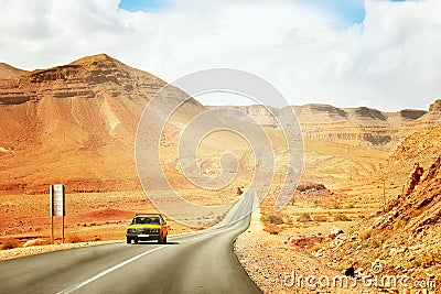 The yellow taxi rides along the mountain road in the Mid Atlas Mountains. Stock Photo