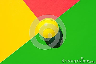 Yellow tennis ball on green red triangle intersection. Abstract colorful graphic geometric background. Business innovation Stock Photo