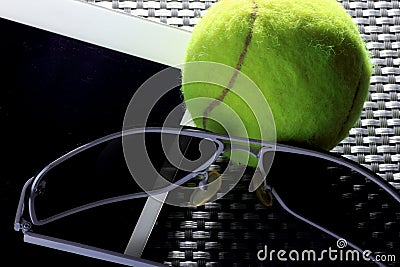 Creative Set Tennis ball, tablet computer and black sunglasses, close-up, on metal background. Stock Photo