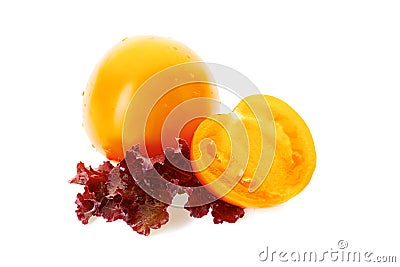 Yellow tomatoe with half slice and salad leaves on white Stock Photo