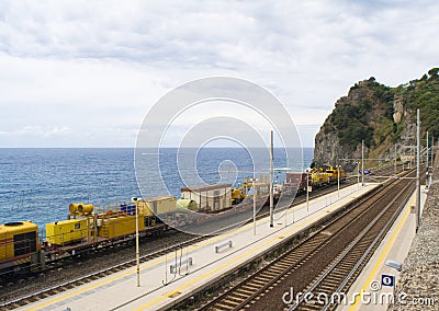 Yellow train in front of the ocean in Corniglia, Italy. Stock Photo