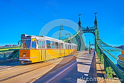 The yellow trams on the green Liberty Bridge, Budapest, Hungary Editorial Stock Photo