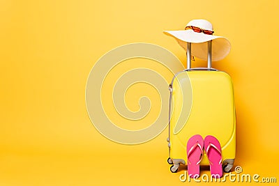 Yellow travel bag with flip flops Stock Photo