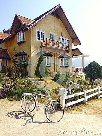 Yellow two-storey house with a garden and bike Editorial Stock Photo
