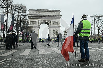 Yellow vests - Gilets jaunes protests - Protester holding a french flag stands in front of riot police Editorial Stock Photo