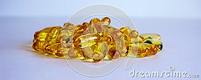 Yellow vitamins tablets, fish oil, Omega Vitamin E. Pills on a blue background. Web banner. Beautiful background Stock Photo