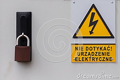 Yellow warning sign and inscription on the electrical box in Polish language. Stock Photo