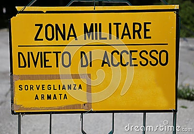 Yellow sign at military zone in italy and text that means Milita Stock Photo