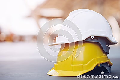 Yellow and white hard safety wear helmet hat in the project at construction site Stock Photo