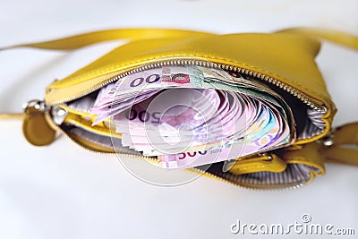 Yellow women's purse with new Qatari money banknotes, white background Stock Photo