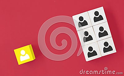 Yellow wooden cube with person icon stand out from the crowd on blue background. Dissenting opinion, divergent views and different Stock Photo