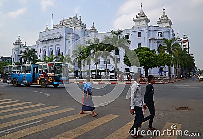 Yellow zebra crossing with a public bus and Yangon City Hall in the background Editorial Stock Photo