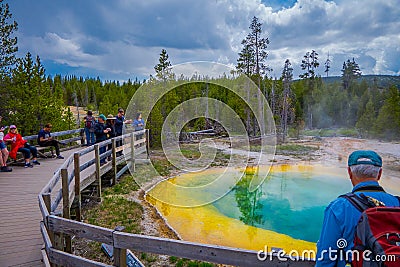 YELLOWSTONE, MONTANA, USA MAY 24, 2018: Outdoor view of tourists walking and taking picture of beautiful and colorful Editorial Stock Photo