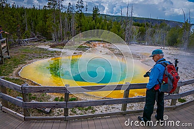 YELLOWSTONE, MONTANA, USA MAY 24, 2018: Outdoor view of tourists walking and taking picture of beautiful and colorful Editorial Stock Photo