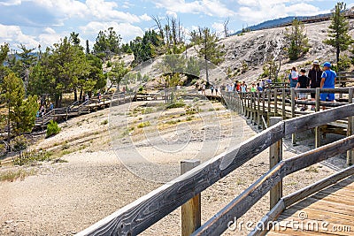 YELLOWSTONE NATIONAL PARK, WYOMING, USA - JULY 17, 2017: Tourists on boardwalk at Mammoth Hot Springs Terraces. Yellowstone Park, Editorial Stock Photo