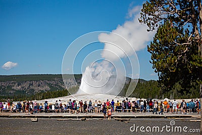 Yellowstone, Wyoming, USA, August 19, 2019, tourists gather around to watch Old Faithful Giser erupt Editorial Stock Photo