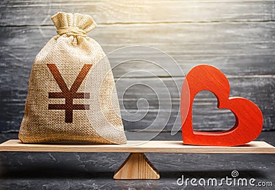 Yen Yuan money bag and red heart on scales. Health life insurance financing concept. Subsidies Stock Photo