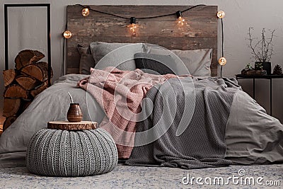 Yerba matte on wooden plate on grey woolen pouf in stylish bedroom Stock Photo