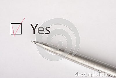 Yes - checkbox with a tick on white paper with metal pen. Checklist concept Stock Photo