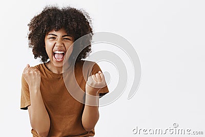 Yes we did it team. Portrait of joyful excited and emotive happy dark-skinned female student cheering for favorite team Stock Photo