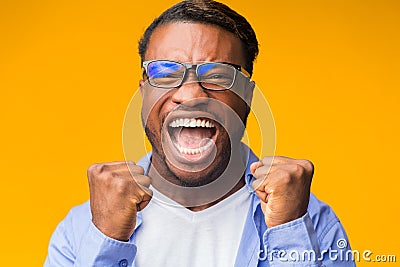 Emotional Black Man Screaming Shaking Fists Standing On Orange Background Stock Photo